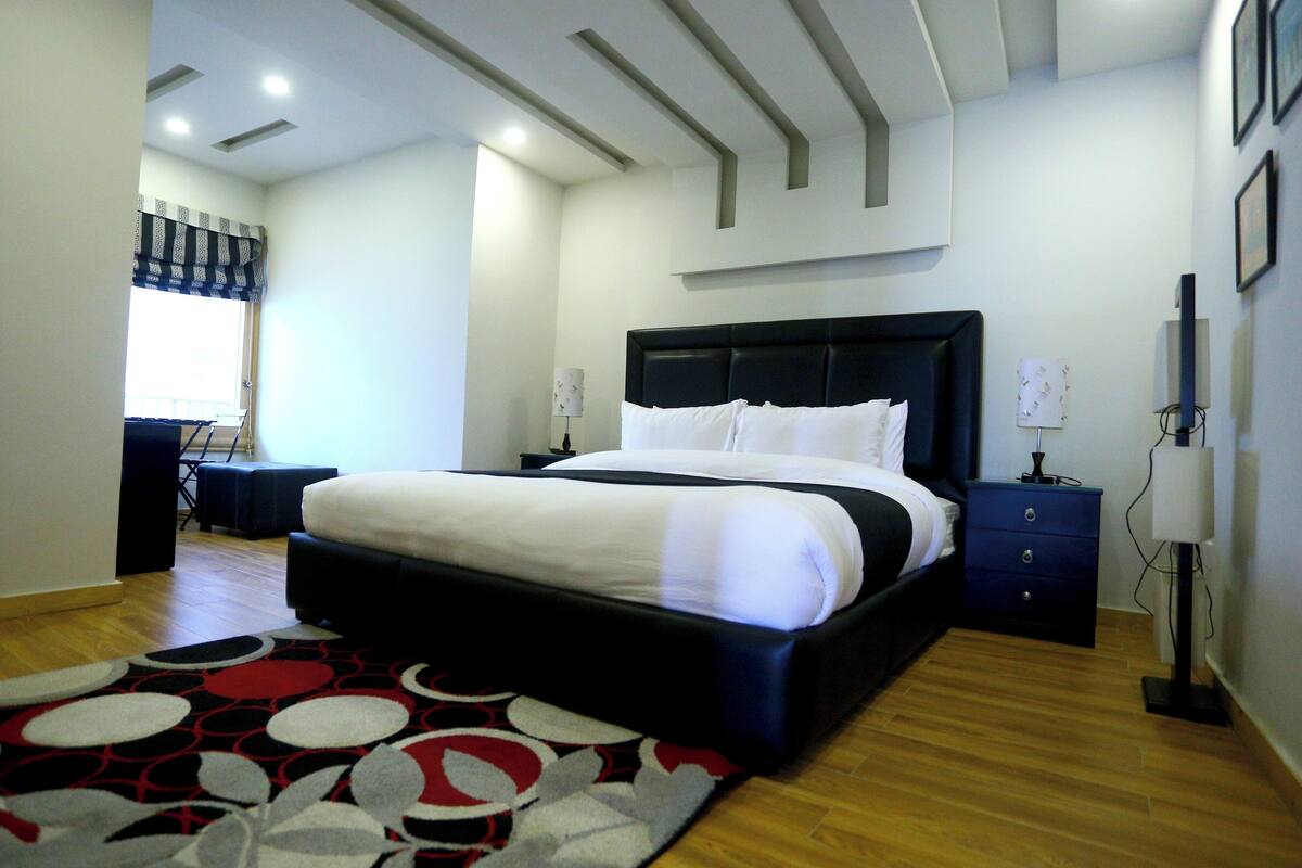Ein modernes Schlafzimmer mit einem großen Bett, einem Schreibtisch und einem Stuhl.