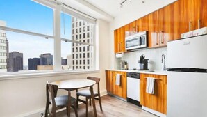 Eine moderne Küche mit Holzschränken, einem weißen Kühlschrank und einem Fenster mit Blick auf die Stadt.