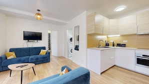 A modern apartment with a living room, a kitchen, and a dining area.