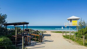Un sentier qui longe la plage et mène à un poste de surveillance des sauveteurs, d’où l’on a une vue dégagée sur l’océan.