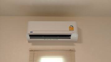 Un aire acondicionado blanco, fijado a la pared, con el logo de la marca visible y una etiqueta que indica tecnología inverter.
