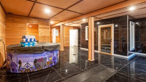 Un hall d’hôtel avec des boiseries, un comptoir d’accueil au design coloré et une porte en verre donnant sur une pièce sombre.