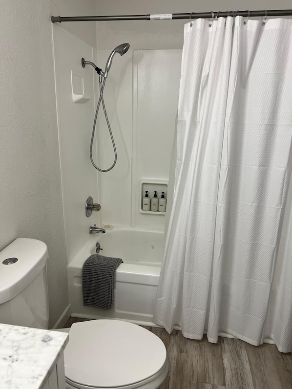 A bathroom with a toilet, a shower, and a bathtub.