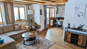 Un salon confortable avec un canapé, un fauteuil, une table basse et un coin repas comprenant une table et des chaises.