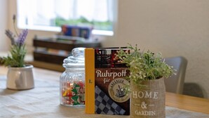 A table with a book titled 'Ruhrpott für Heimat' and a potted plant in a 'HOME & GARDEN' pot.