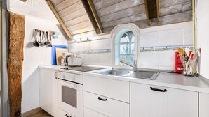 A kitchen with white cabinets, a double sink, and a window with a view. - Apartment 1 with Shared Garden, Terrace, and Wi-Fi (Rodenäs)