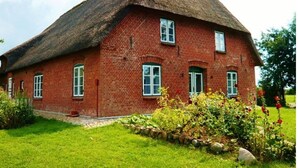 A red brick house with a thatched roof and white-framed windows. - Apartment 1 with Shared Garden, Terrace, and Wi-Fi (Rodenäs)