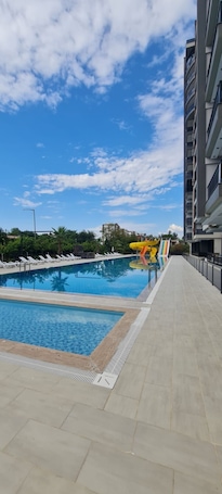 Una piscina al aire libre de temporada, sillones reclinables de piscina