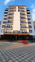 A modern hotel building with a sign reading "PANORAMA HOTEL".