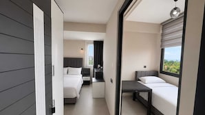 A modern hotel room with a bed, a desk, and a view of the outdoors. - Mersin Panorama Otel (Erdemli)
