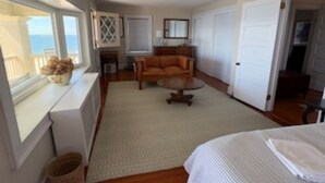 Una stanza con un letto, un divano, un tavolino, una finestra vista e una ventola a soffitto.