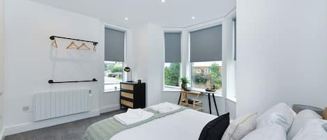 2 habitaciones, escritorio y tabla de planchar con plancha