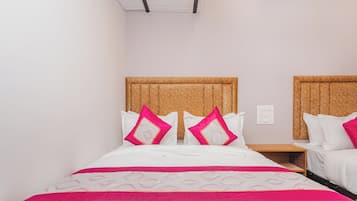 Una habitación de hotel con una cama, dos mesitas de noche y una lámpara en el techo.