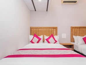 A hotel room with a bed, two nightstands, and a ceiling light. - AFRA DORMITORY (Mumbai)