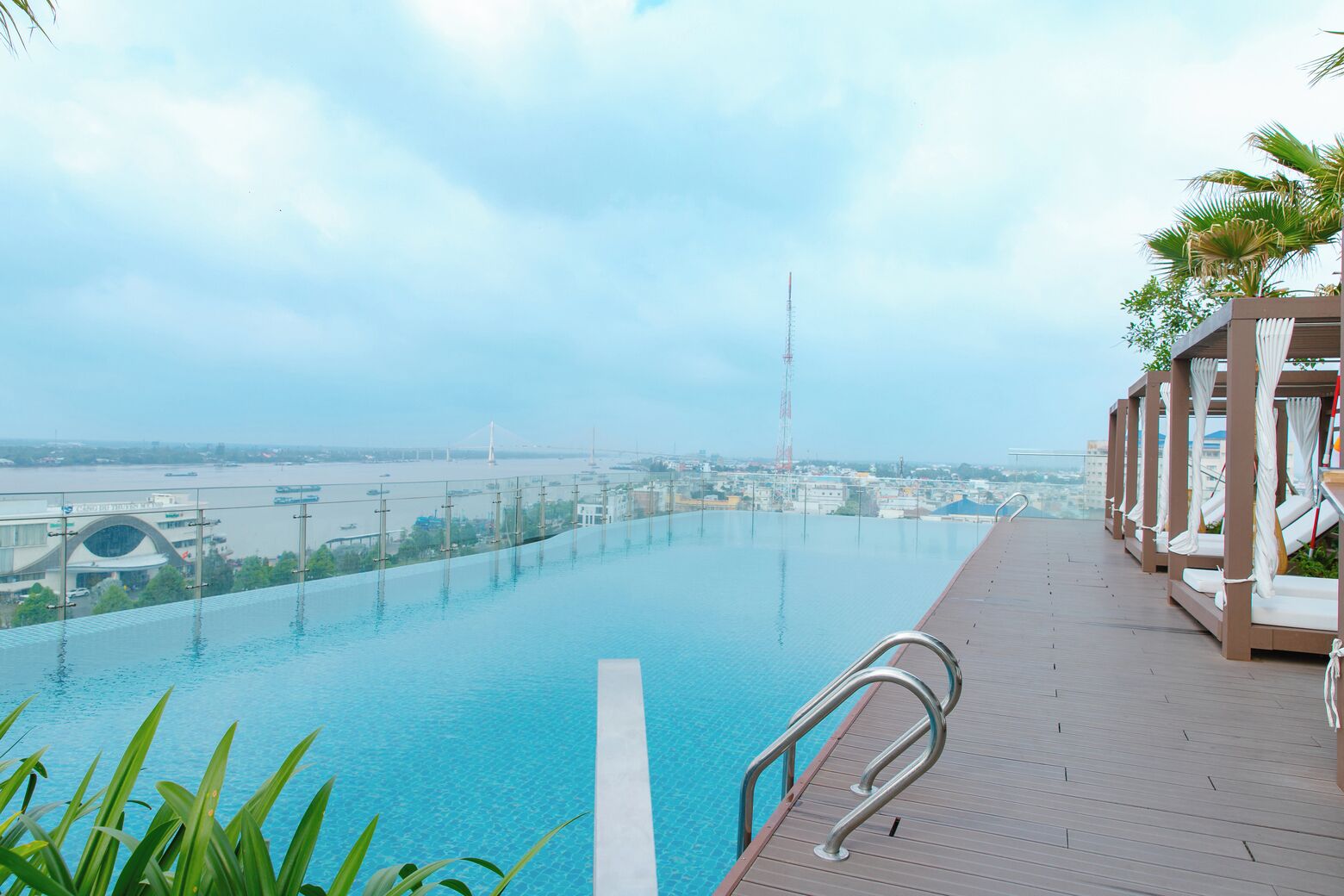 Una piscina infinita en la azotea con vistas a un puente y al paisaje urbano.