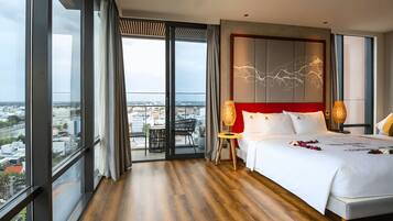 Ein modernes Hotelzimmer mit einem großen Bett, Blick auf die Stadt und einem Balkon.
