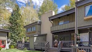 Une maison moderne à deux étages, dotée d’un porche abrité, d’une petite terrasse et d’une pelouse bien entretenue.