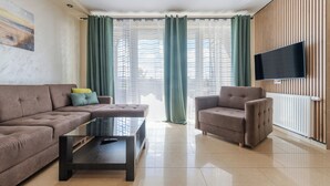 A modern living room with a sofa, armchair, and a coffee table. - Apartamenty Sun & Snow Villa Nord (Wladyslawowo)