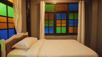 A bedroom with a bed, curtains, and a window with a view.