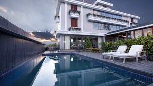 Un edificio moderno con piscina e zona salotto all'aperto.