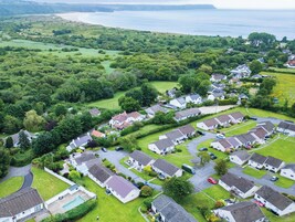 Vista aérea de una zona residencial con casas, carreteras y una costa.