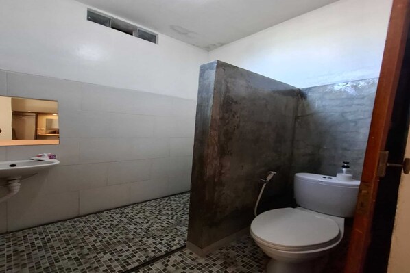 A bathroom with a tiled floor, a sink, a toilet, and a shower area. - Capital O 94274 Homestay Balimoelih (Yogyakarta)