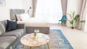 Et moderne soveværelse med seng, sofa, sofabord og stol.