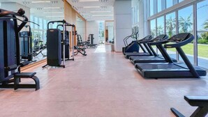 Ett modernt gym med löpband, styrketräningsmaskiner och speglar.