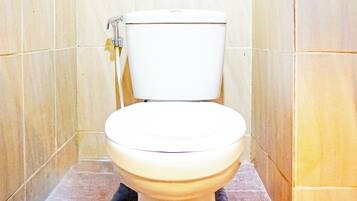 A toilet in a bathroom with beige tiled walls and floor.