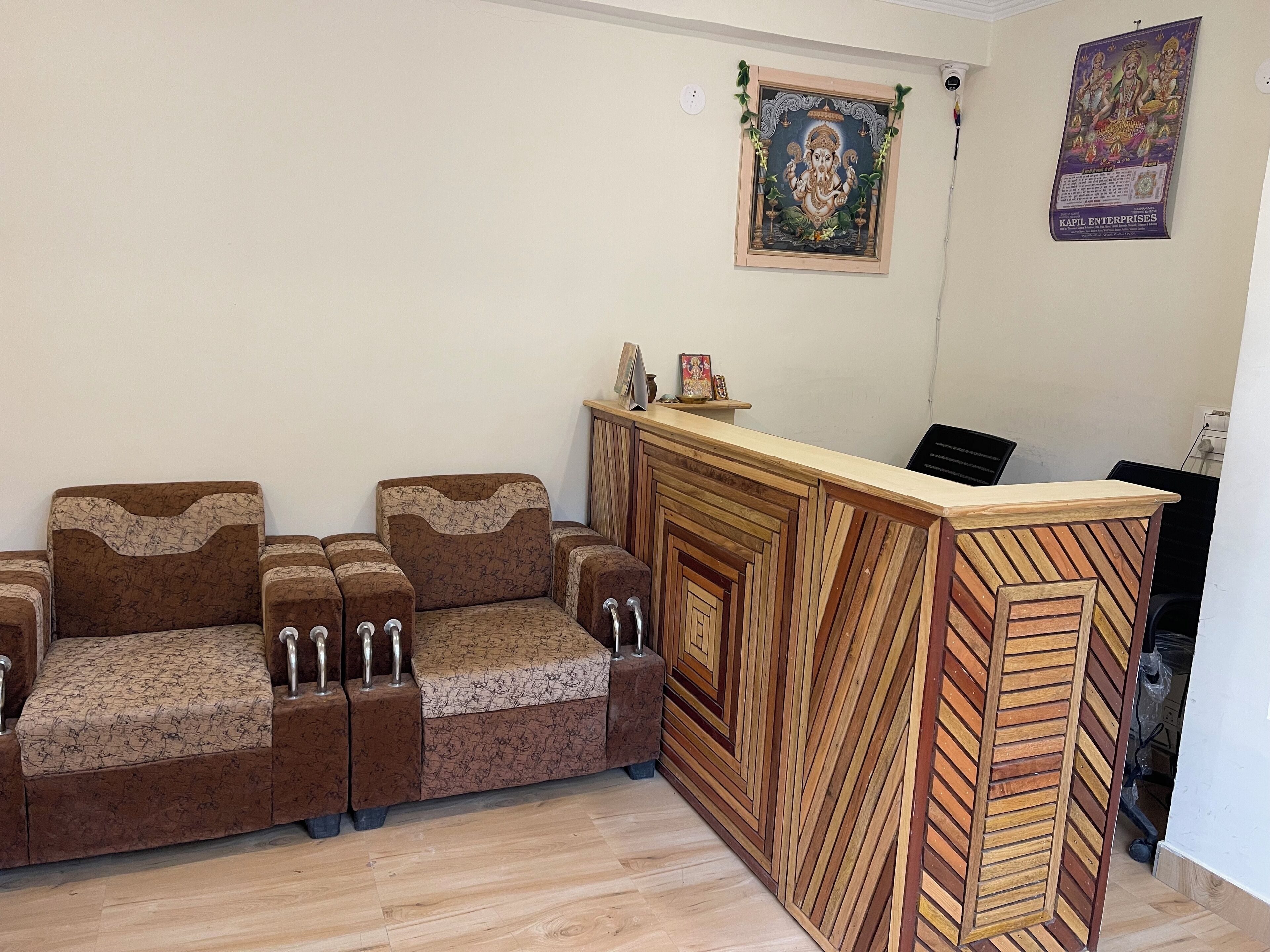 A reception area with a wooden reception desk, a sofa, and a wall-mounted religious poster.