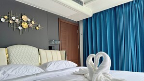 Habitación de hotel con cama, aire acondicionado de pared, armario de madera y cortina azul.