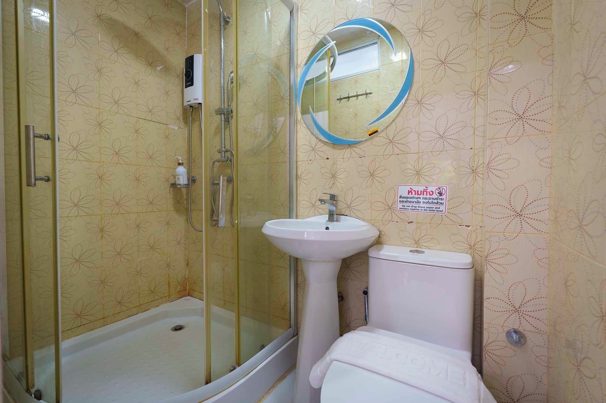 A bathroom with a glass-enclosed shower, a pedestal sink, and a toilet.