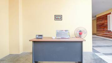 A reception desk with a radio, a small bowl, and a fan.
