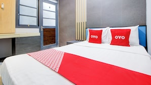 Une chambre d’hôtel avec un lit, un bureau et une armoire.