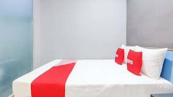 A bed with white and red bedding, two red pillows with "YOYO" text, and a wooden headboard.