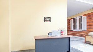 Un comptoir d’accueil avec un ventilateur, un tableau encadré et un mur en bois.