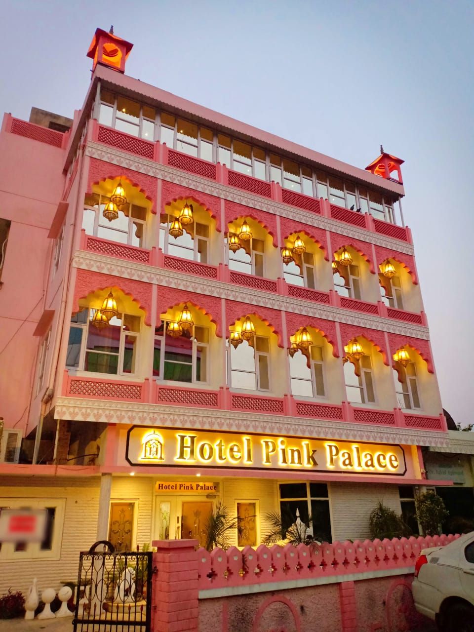 Un edificio de varios pisos con un cartel que dice "Hotel Pink Palace".