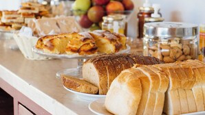Ein Buffet mit verschiedenen Brotsorten und Gebäck, einer Obstschale und Soßen.