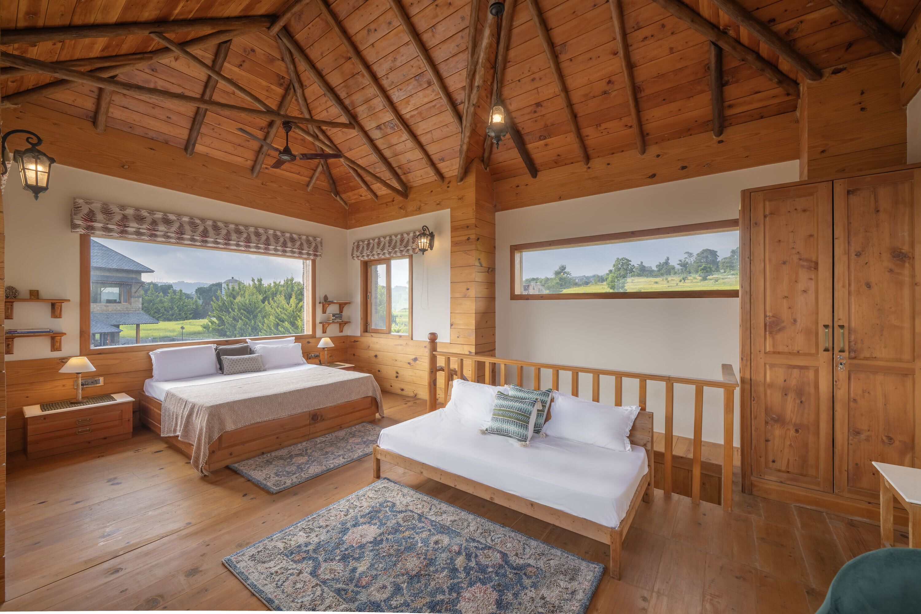 Un dormitorio de cabaña de madera con dos camas, un armario grande y vistas al exterior.