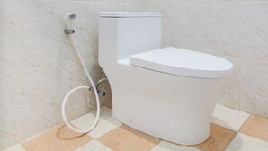 A bathroom with a toilet, a shower, and a tiled floor. - Hotel O Alun-Alun Purwokerto Near Gor Satria Purwokerto Formerly Guest House Blessing (Purwokerto)