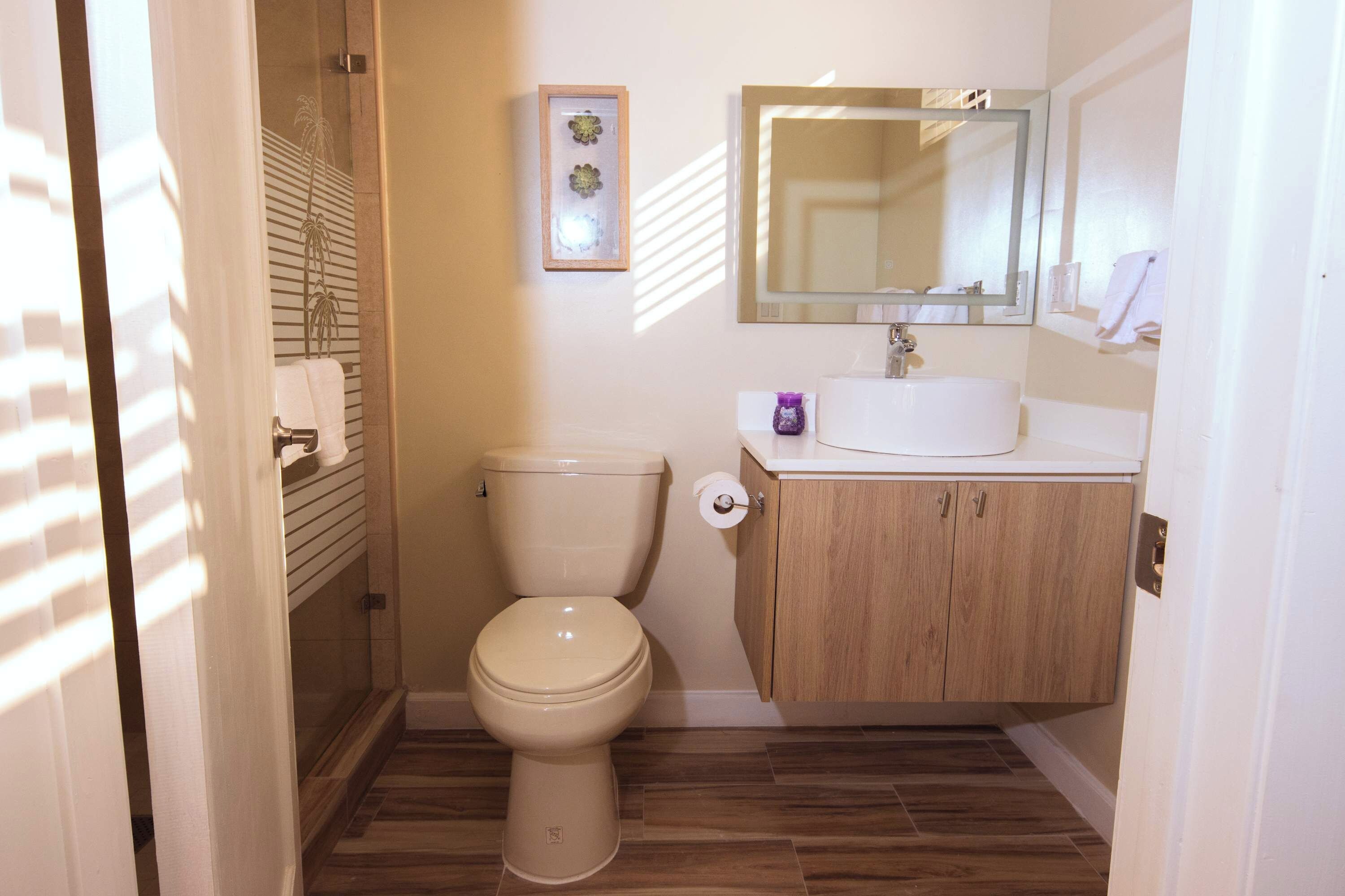 Une salle de bain avec des toilettes, un lavabo et un miroir.
