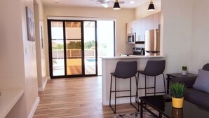 A modern apartment with a kitchen, dining area, and a balcony. - Private Pool Villa Near Long Bay Beach & Grace Bay (Leeward Settlement)