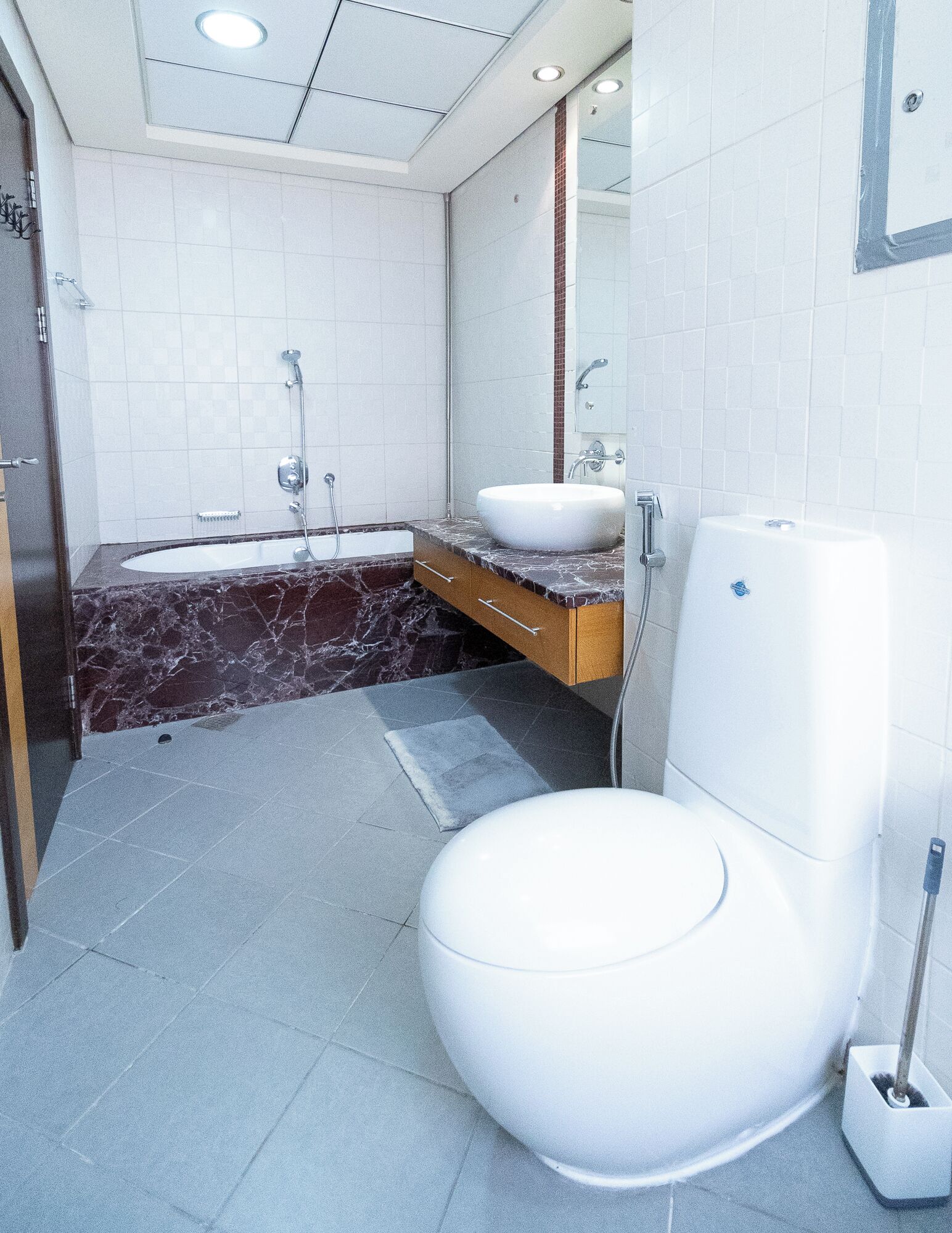 A modern bathroom with a white toilet, a large sink, and a bathtub.