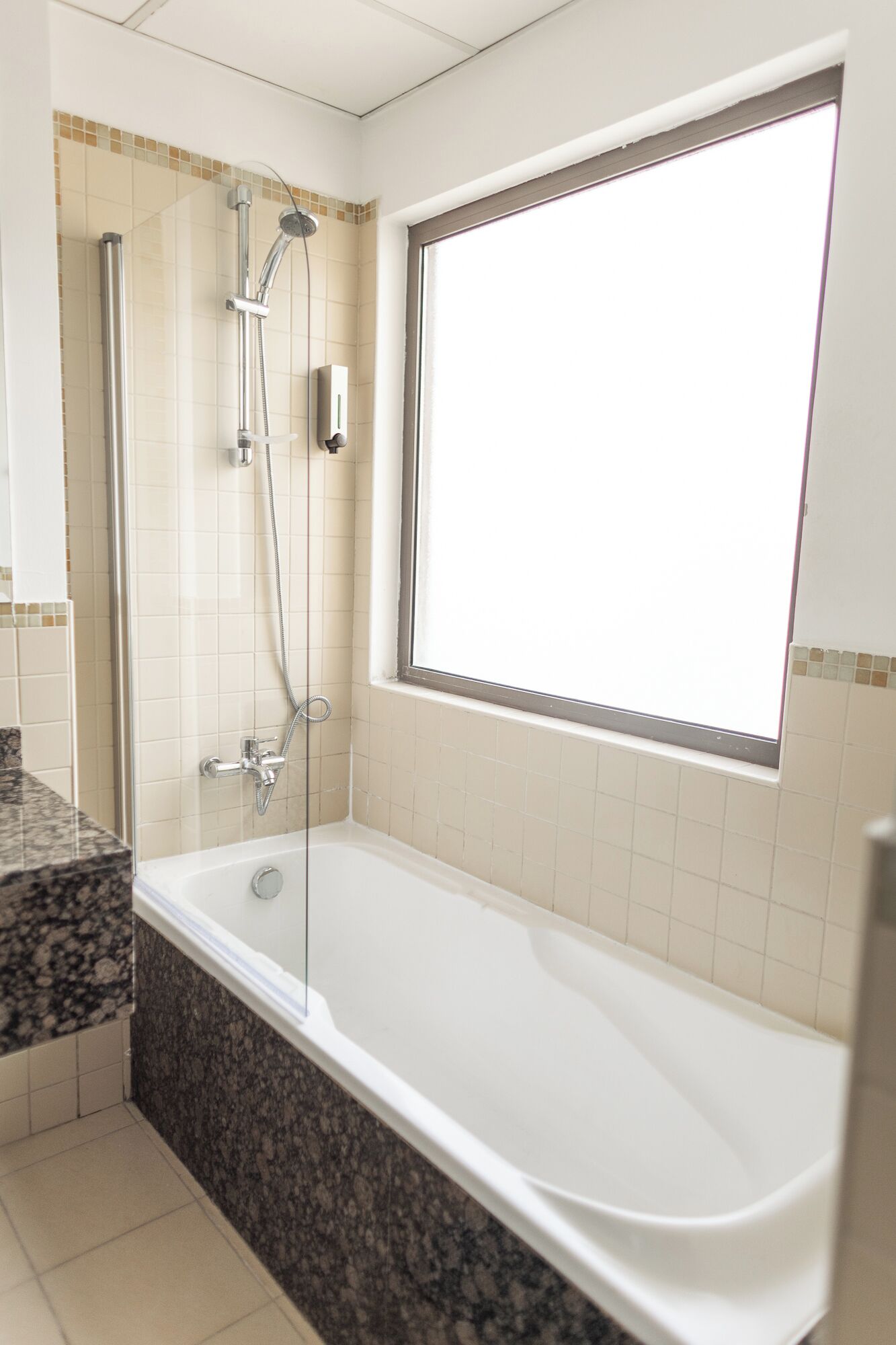 Een moderne badkamer met een inloopdouche, een badkuip en een raam voor natuurlijk licht.