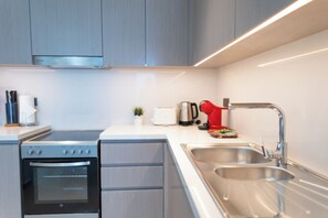 A modern kitchen with stainless steel appliances, a double sink, and a toaster. - HAPPY SEASON | ACT ONE ACT TWO (Dubai)