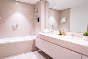 Luxe appartement, balkon, uitzicht op de stad | Badkamer | Een aparte badkuip en douche, een haardroger, badjassen, handdoeken