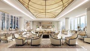 A spacious lobby with a central seating area, large windows, and a modern ceiling design. - HAPPY SEASON | Four Season apartment  (Abu Dhabi)