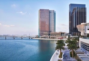 A waterfront hotel with modern architecture, a marina, and a pedestrian bridge.