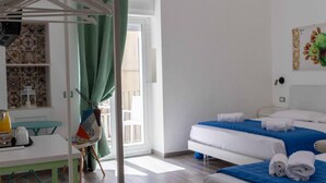 Een hotelkamer met een bed, een tafel met stoel, een kledingrek en uitzicht.
