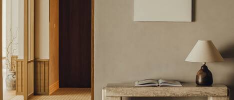 A room with a marble console table, a lamp, and a framed picture on the wall.